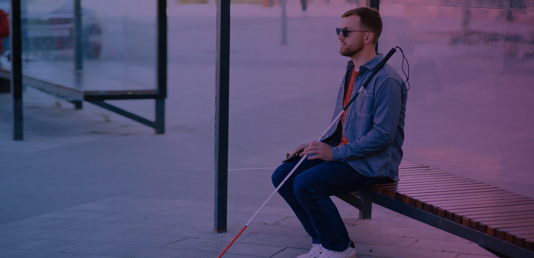 Blinder Mann sitzt in Bushaltestelle